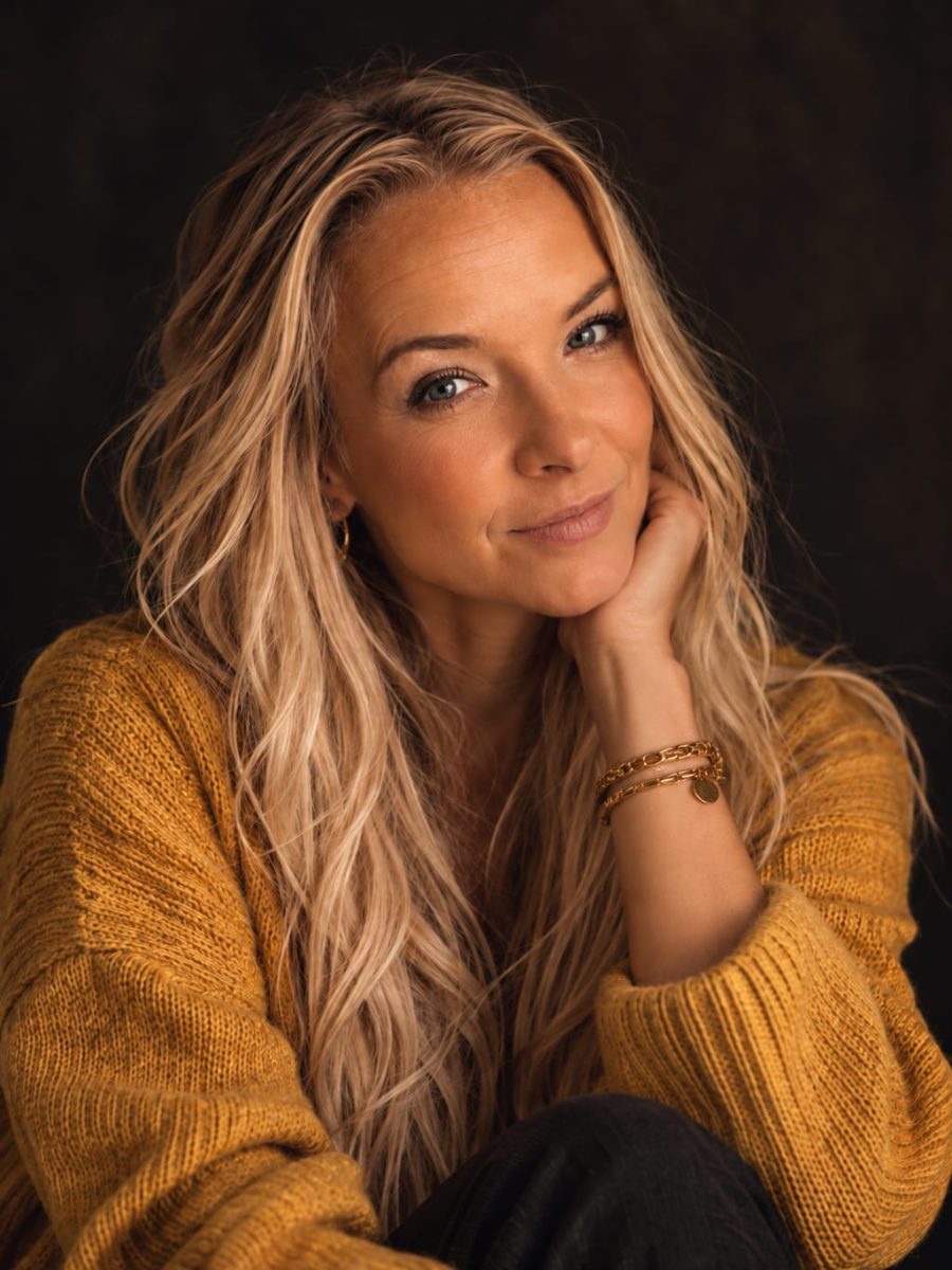 Marina Remmele, lächelnd, im senfgelben Strickpullover
